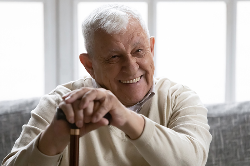 Happy senior safety leaning on cane